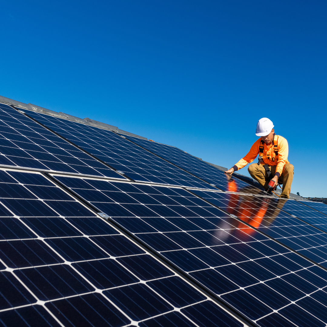 Profissional instalando placas de energia solar em residência
